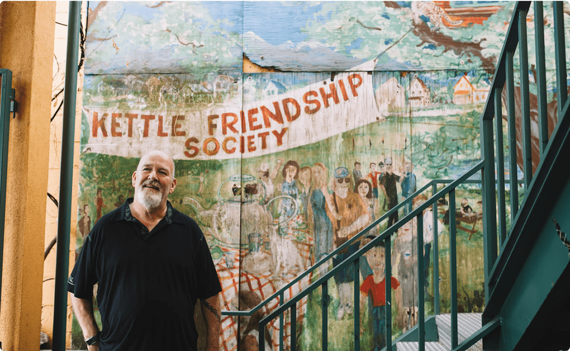 Organizer posing against mural.