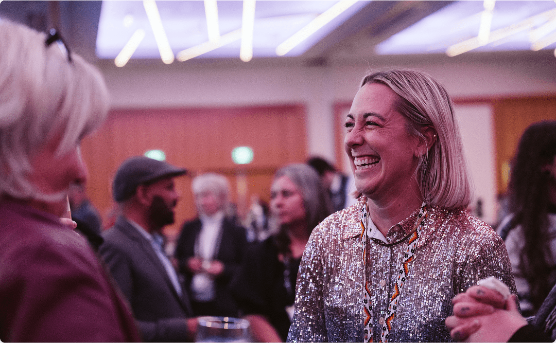 People speaking and laughing at a conference.