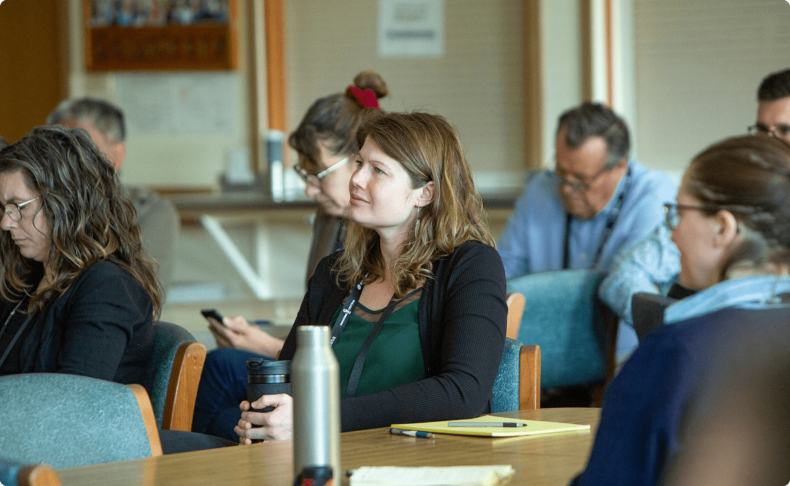 A group listening to a speaker at a RENT event.