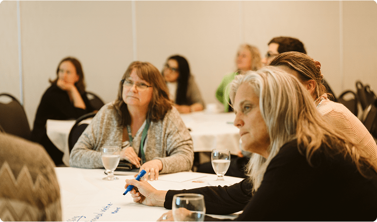 A group of people listening to a speaker at a RENT event.