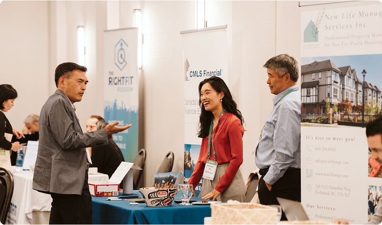 A group of people speaking at a tradeshow booth at a RENT event. 