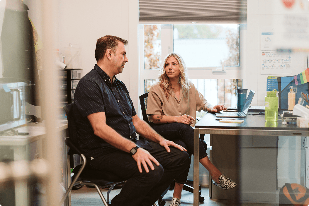 Two people speaking in an office.