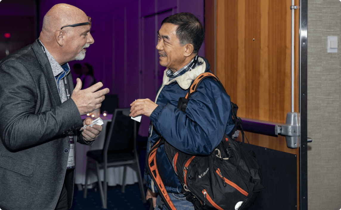 Two men talking at a conference.