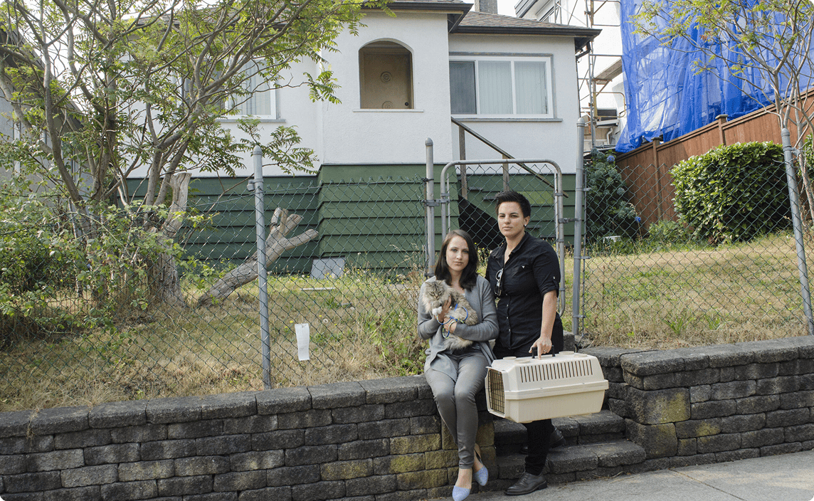 Two tenants outside a home with their pet in a kennel. The mood is sombre.