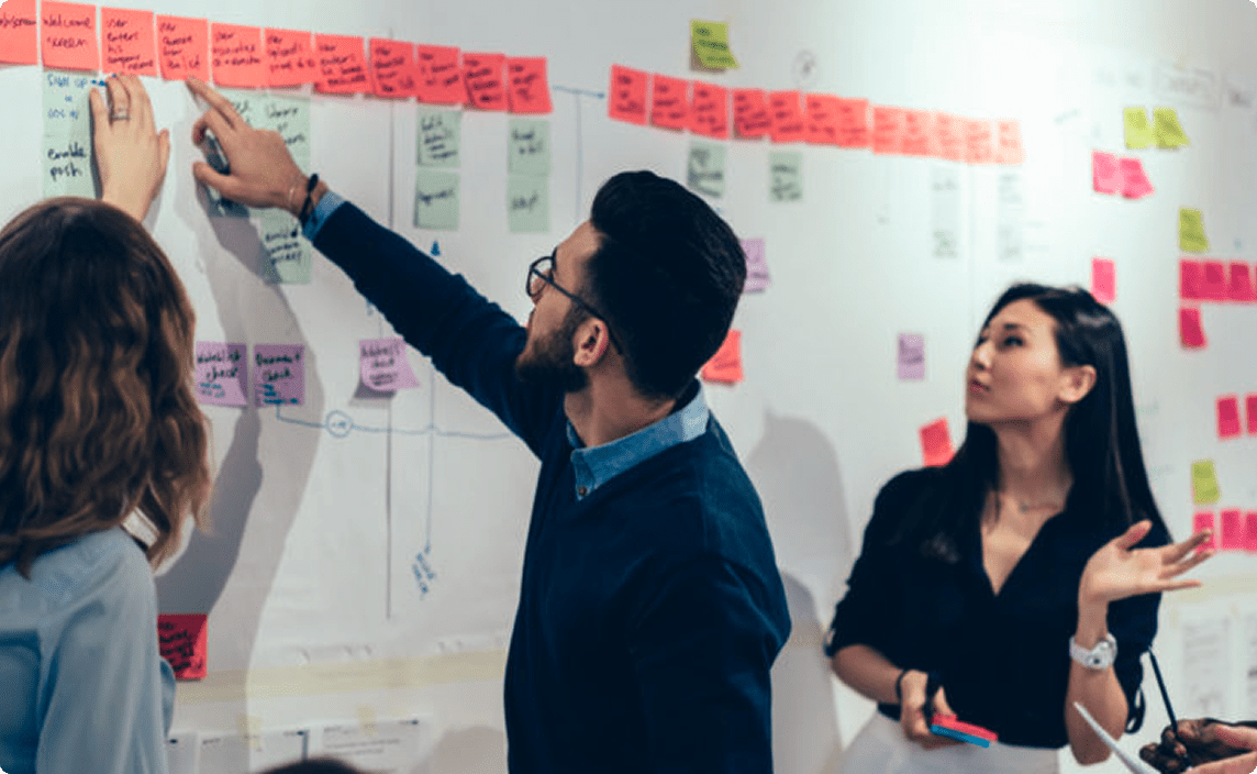 A person pointing to a board at an IAP2 event.