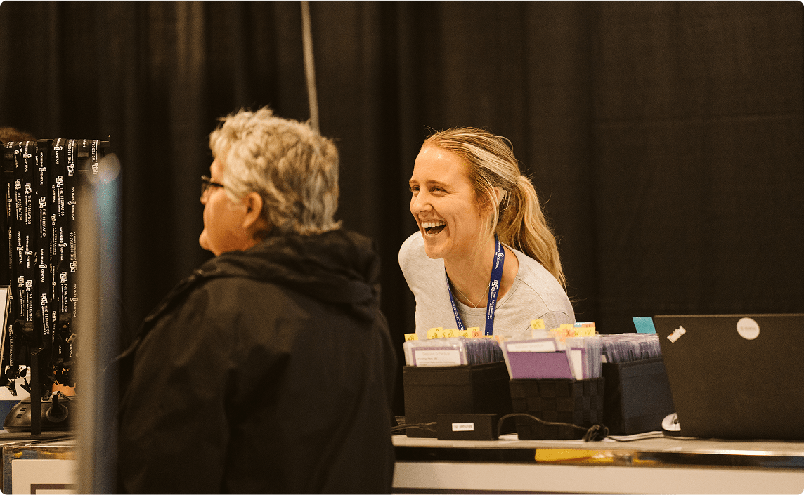 Two people laughing at a conference.