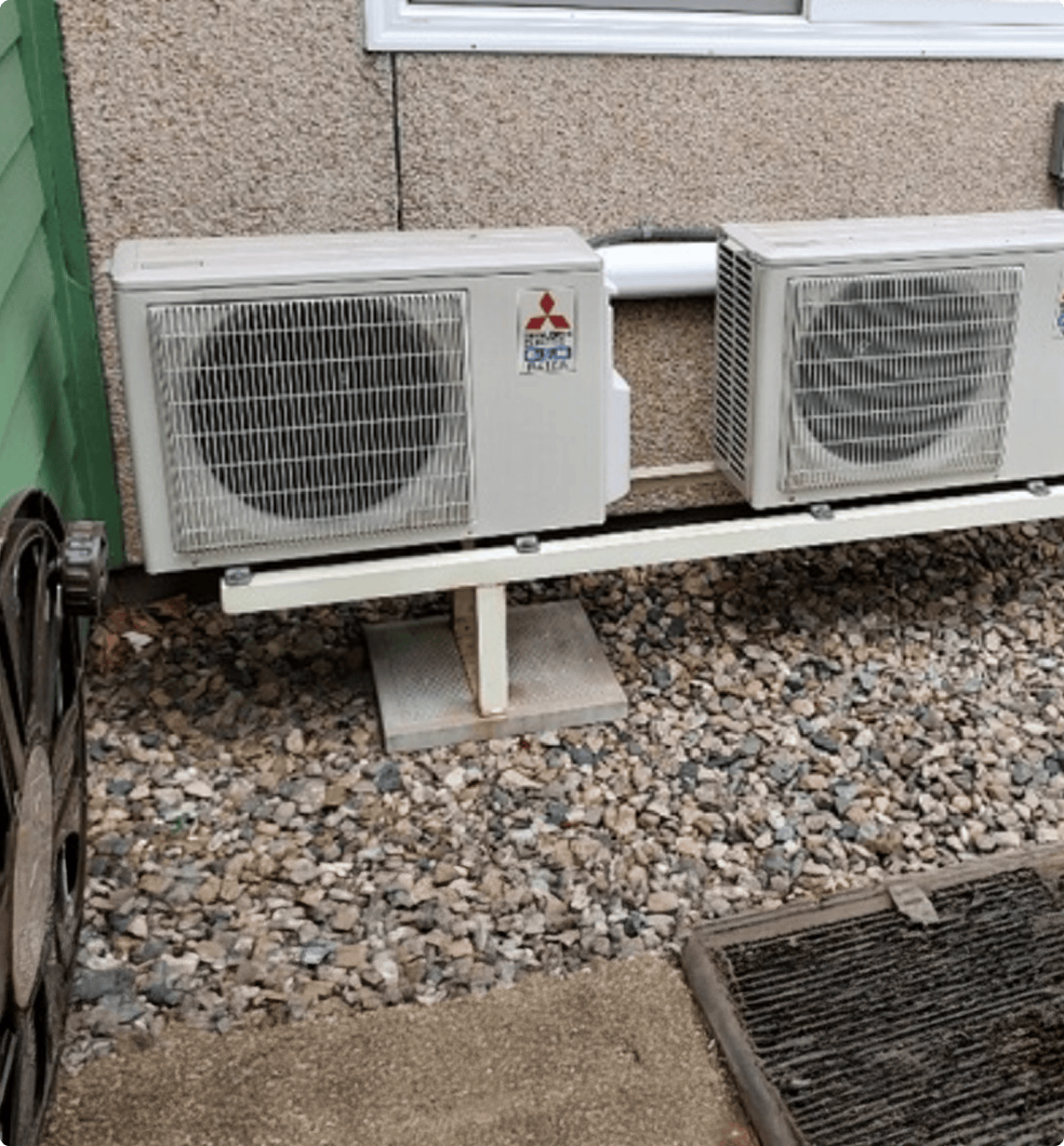 Two heat pumps installed outside a home.