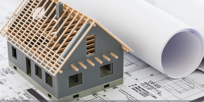 House model figure on top of blueprints