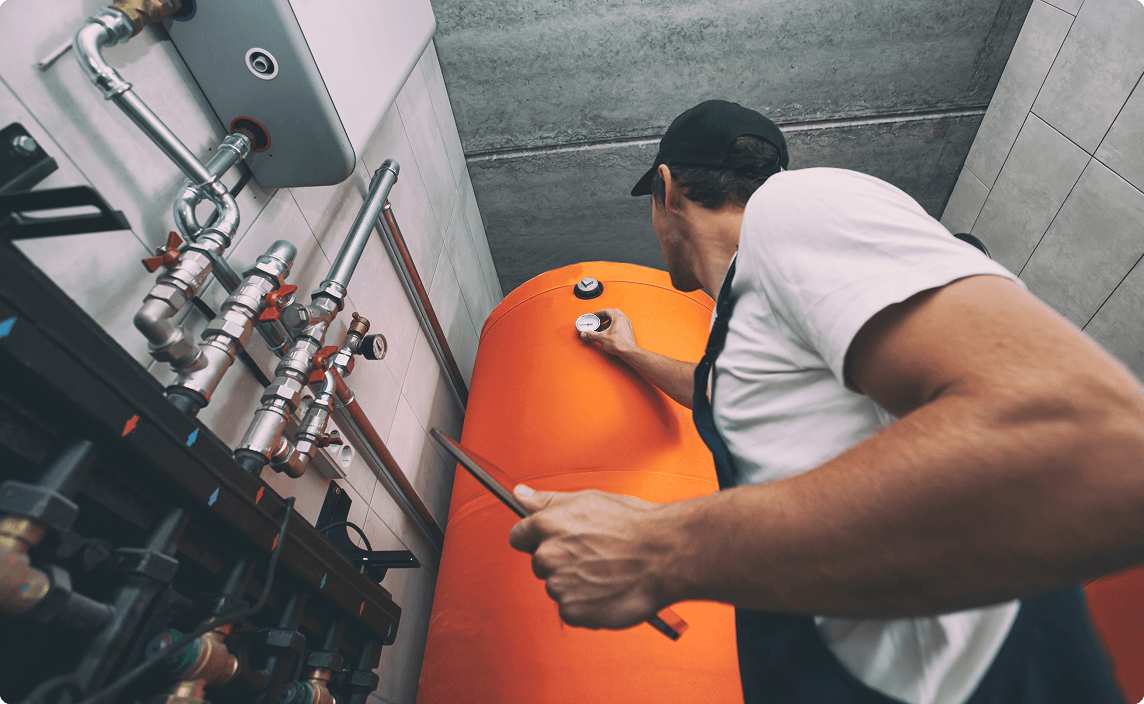 A man inspecting the boiler in a building.