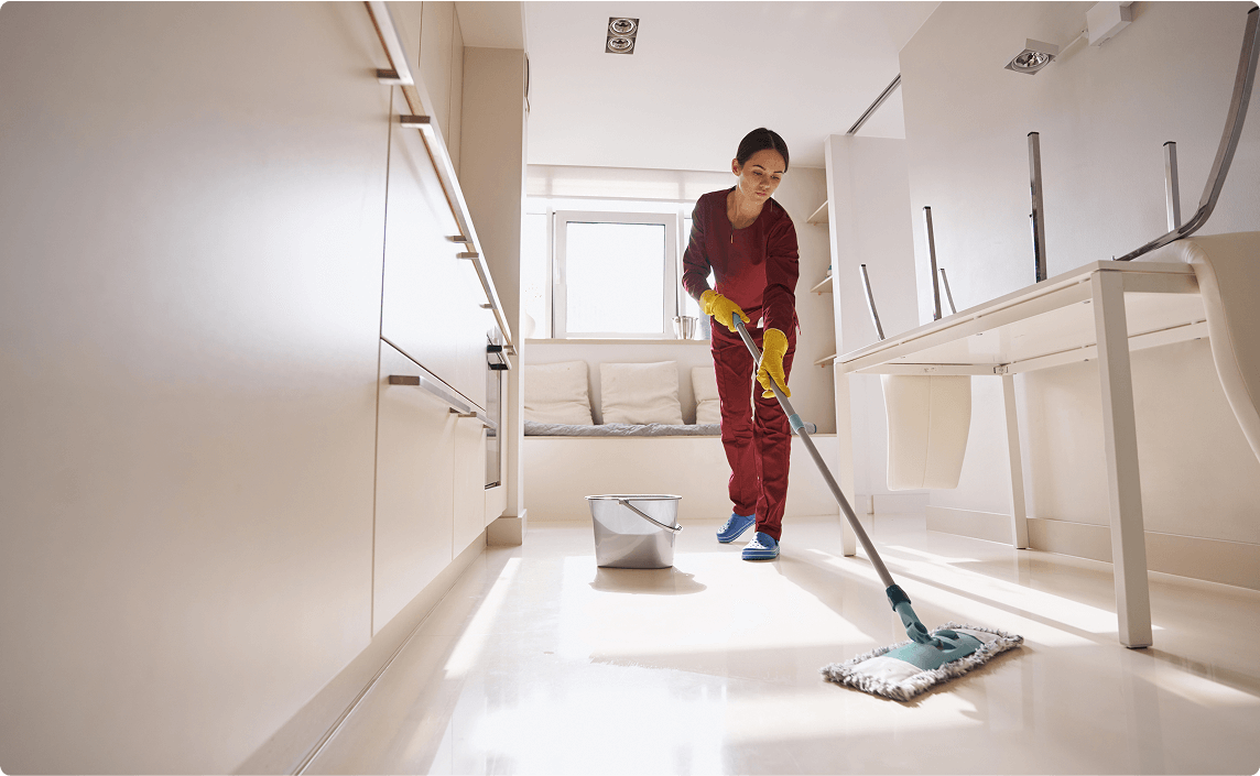 A woman cleaning a hallway.