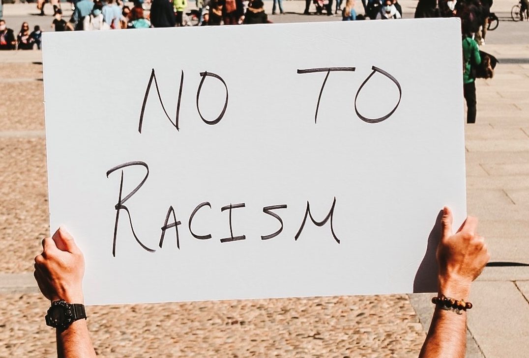 A sign held up that reads: 'No to Racism'.