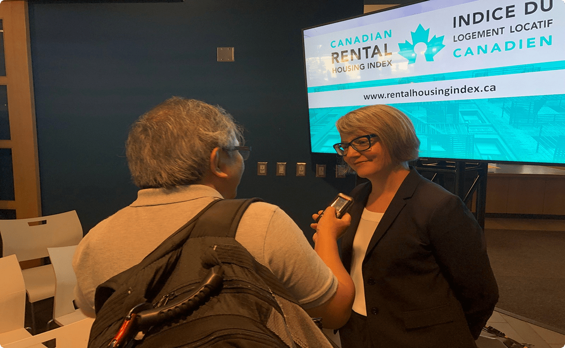 Jill Atkey speaking to another person at a conference.
