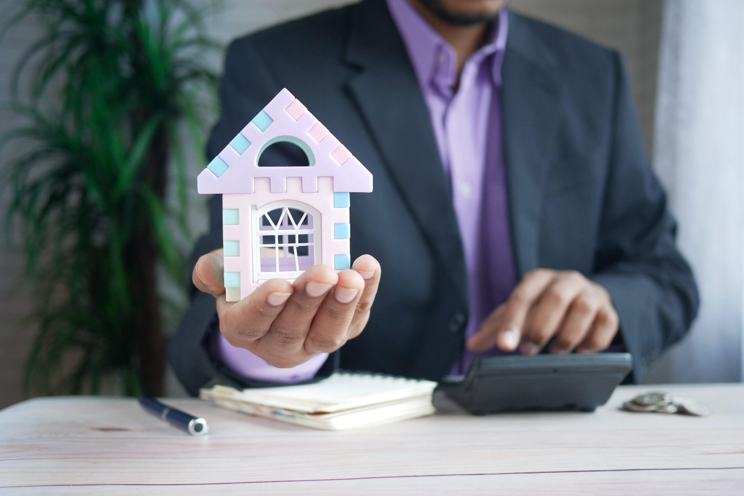 A man holding a toy house.